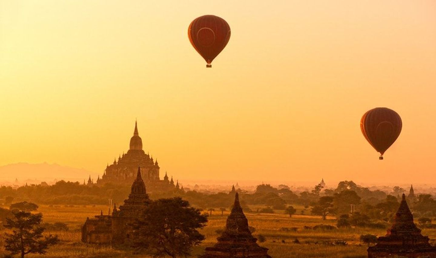 Travel in Asia - Hot air balloons flying over ancient temple buildings at sunrise
