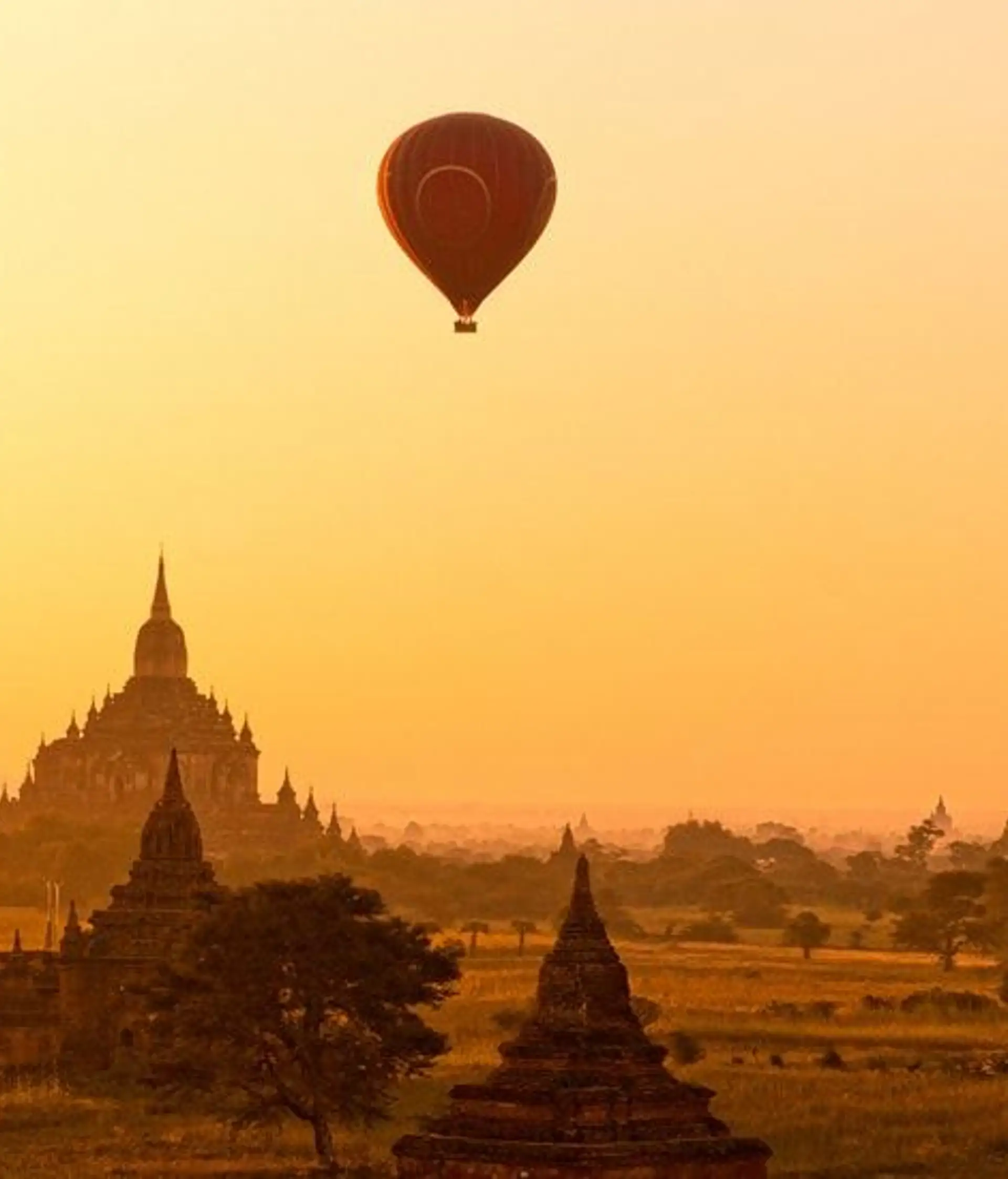Travel in Asia - Hot air balloons flying over ancient temple buildings at sunrise