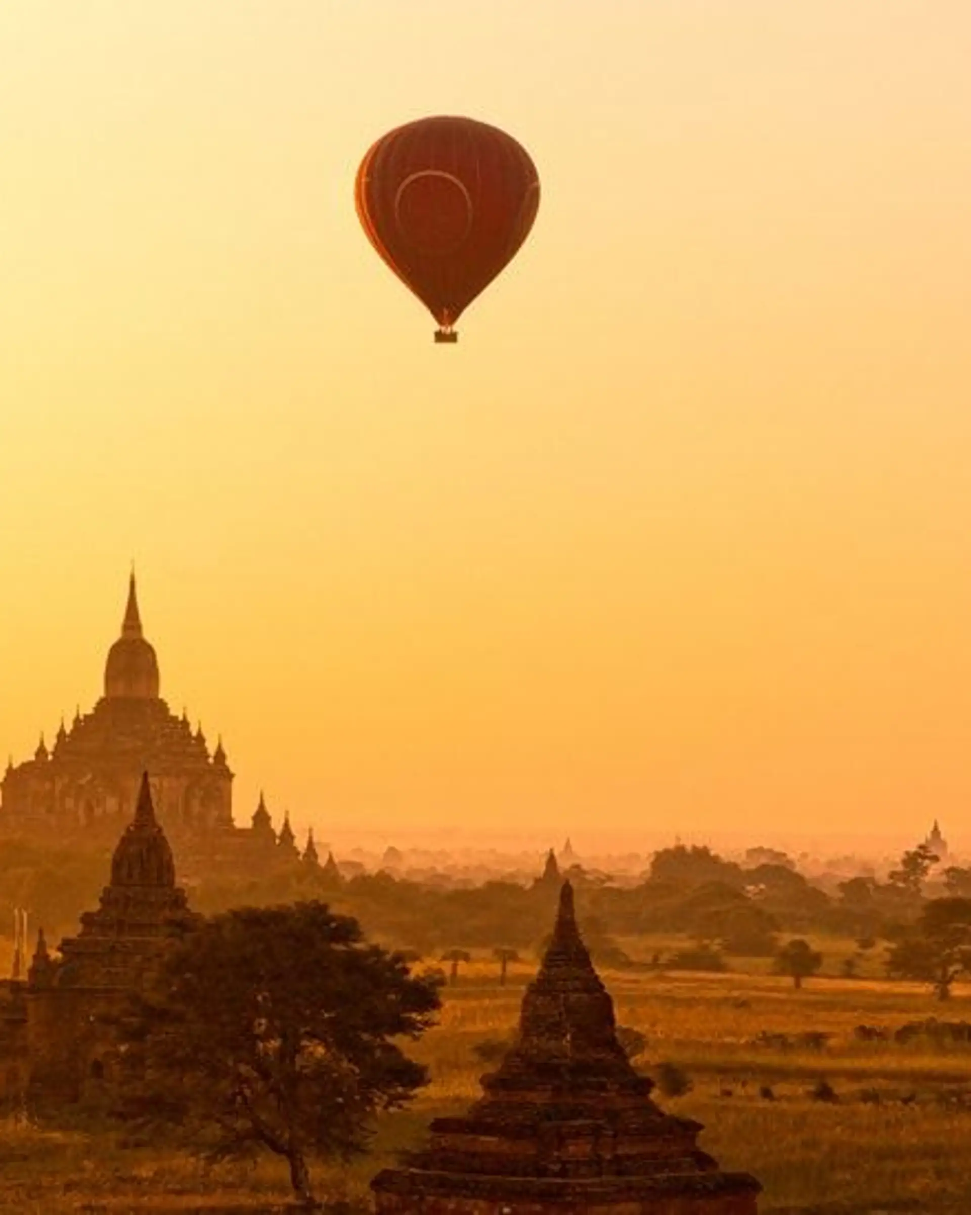 Travel in Asia - Hot air balloons flying over ancient temple buildings at sunrise