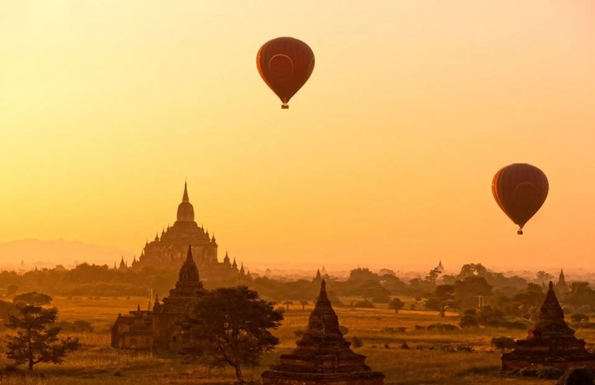 Travel in Asia - Hot air balloons flying over ancient temple buildings at sunrise