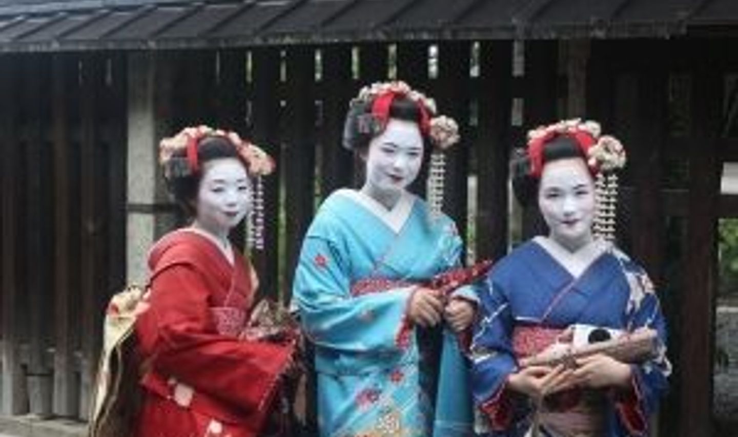 Travel in Asia - Three maiko standing for a picture in full makeup and kimono in Kyoto