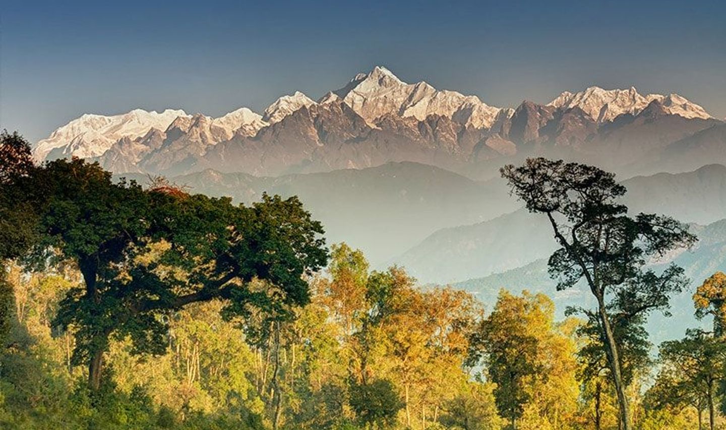 Travel in Asia - Snow-capped Himalayan mountains rising above forested hills in Nepal