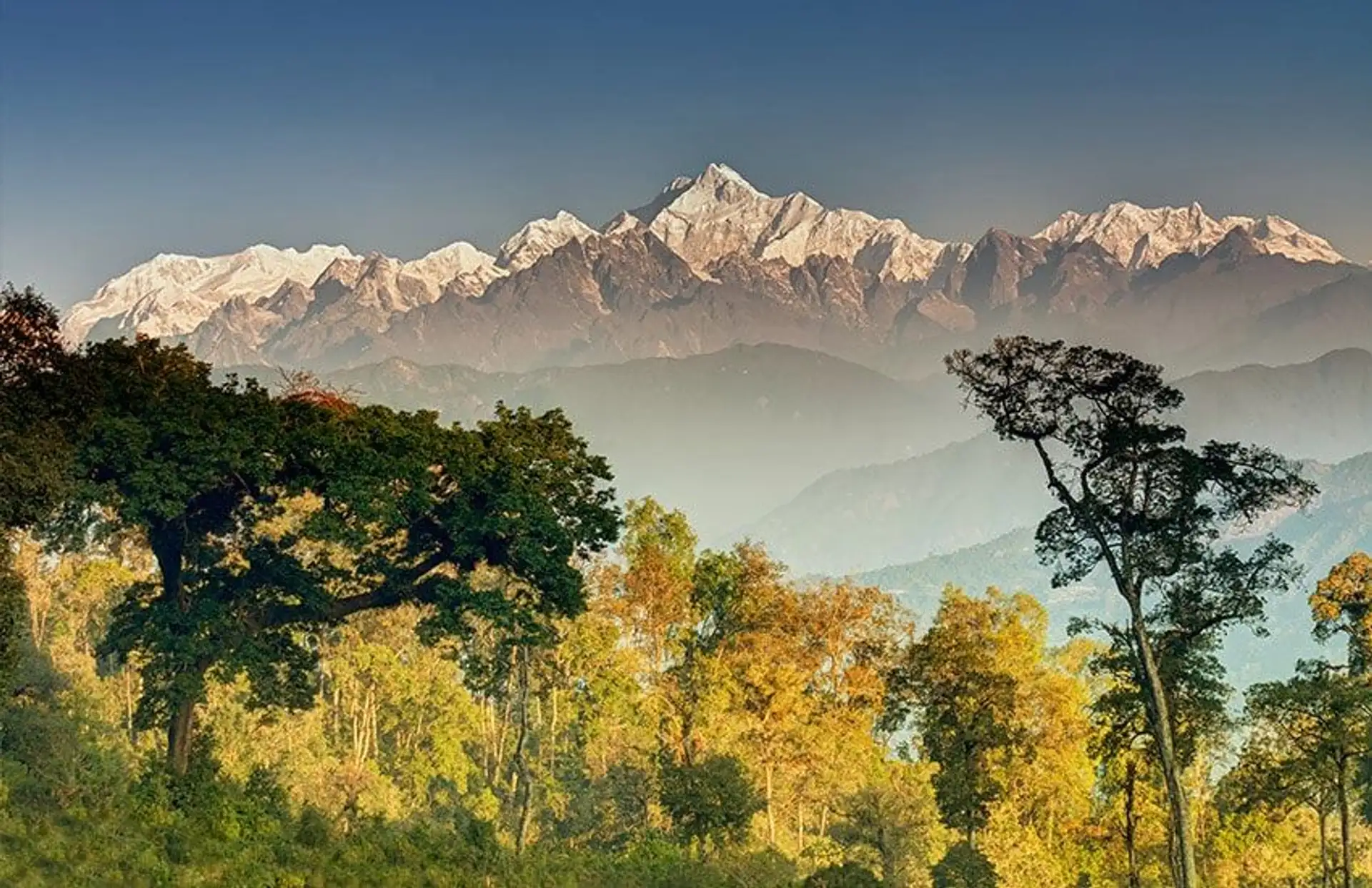 Travel in Asia - Snow-capped Himalayan mountains rising above forested hills in Nepal