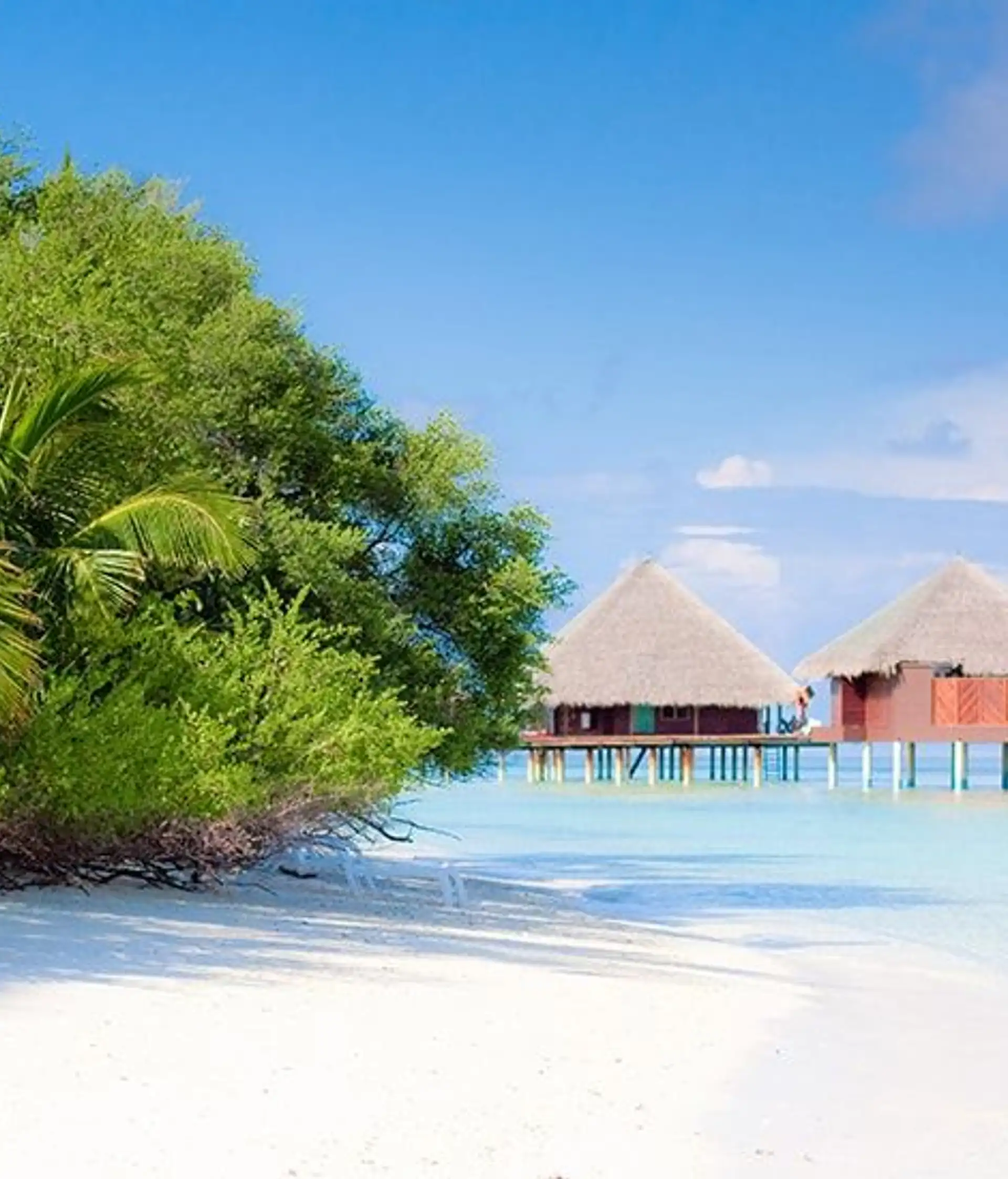 Travel in Asia - Two overwater villas on a white-sand beach on a clear, sunny day in the Maldives