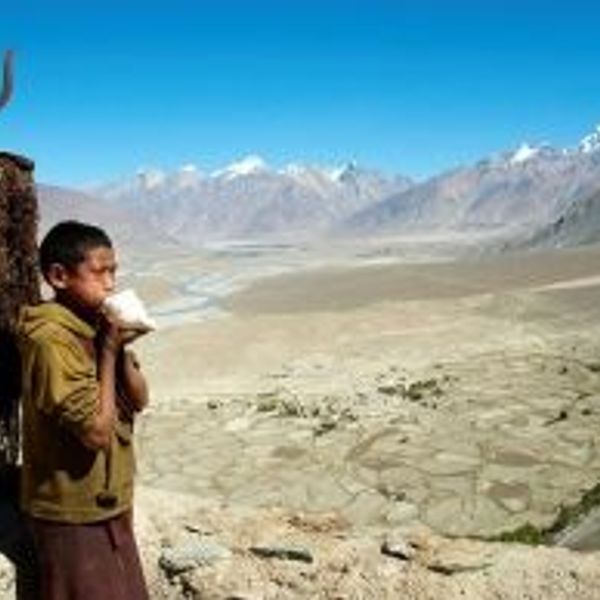 Travel in Asia - A young boy standing in front of the vast highlands near the Karsha Gompa monastery in Zanskar, Ladakh in India