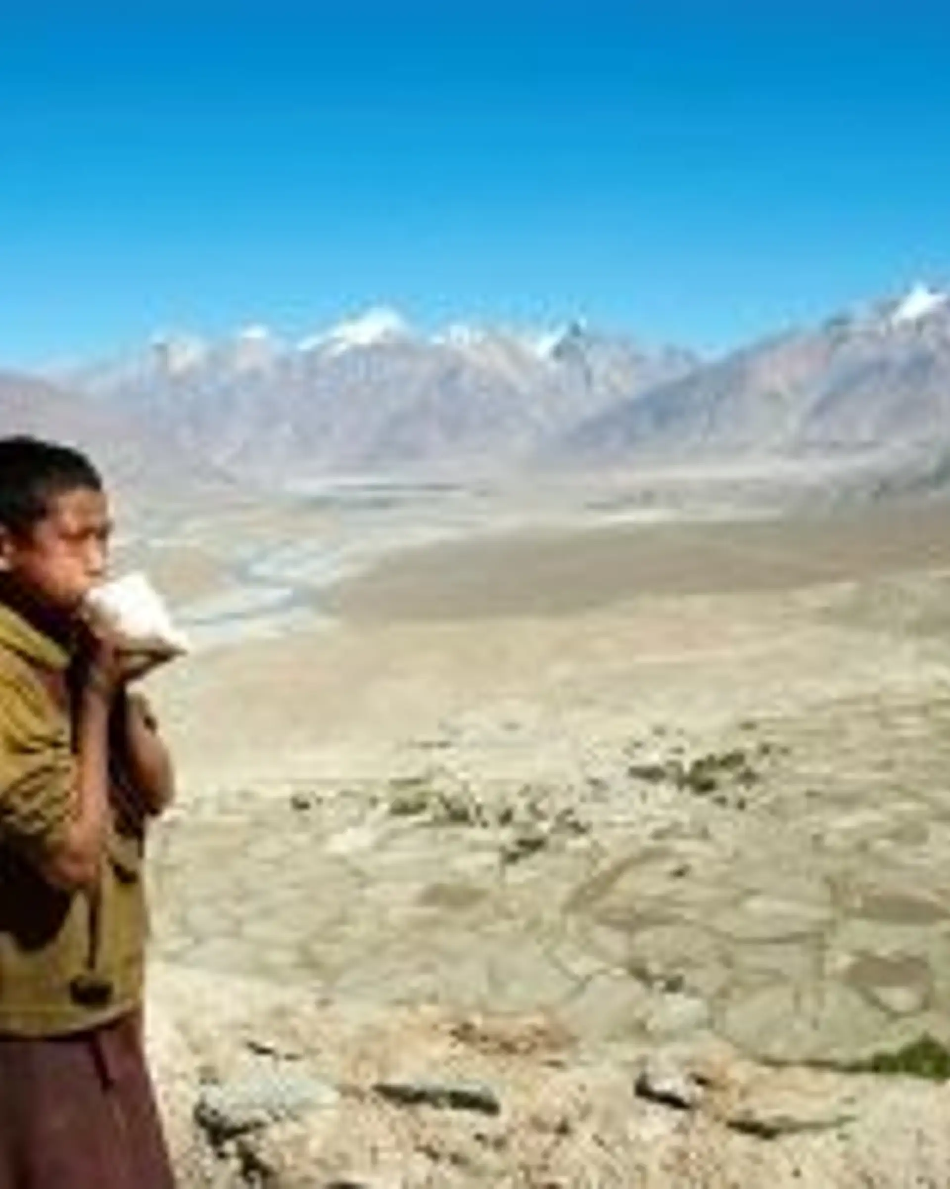 Travel in Asia - A young boy standing in front of the vast highlands near the Karsha Gompa monastery in Zanskar, Ladakh in India