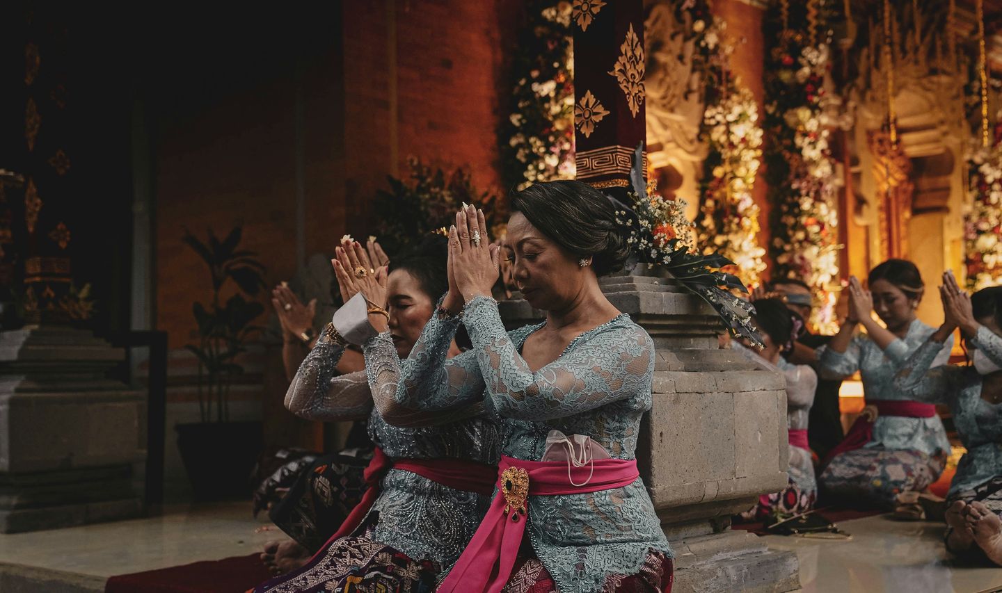 Travel in Asia - Women kneeling in respectful gestures during a traditional Balinese ceremony