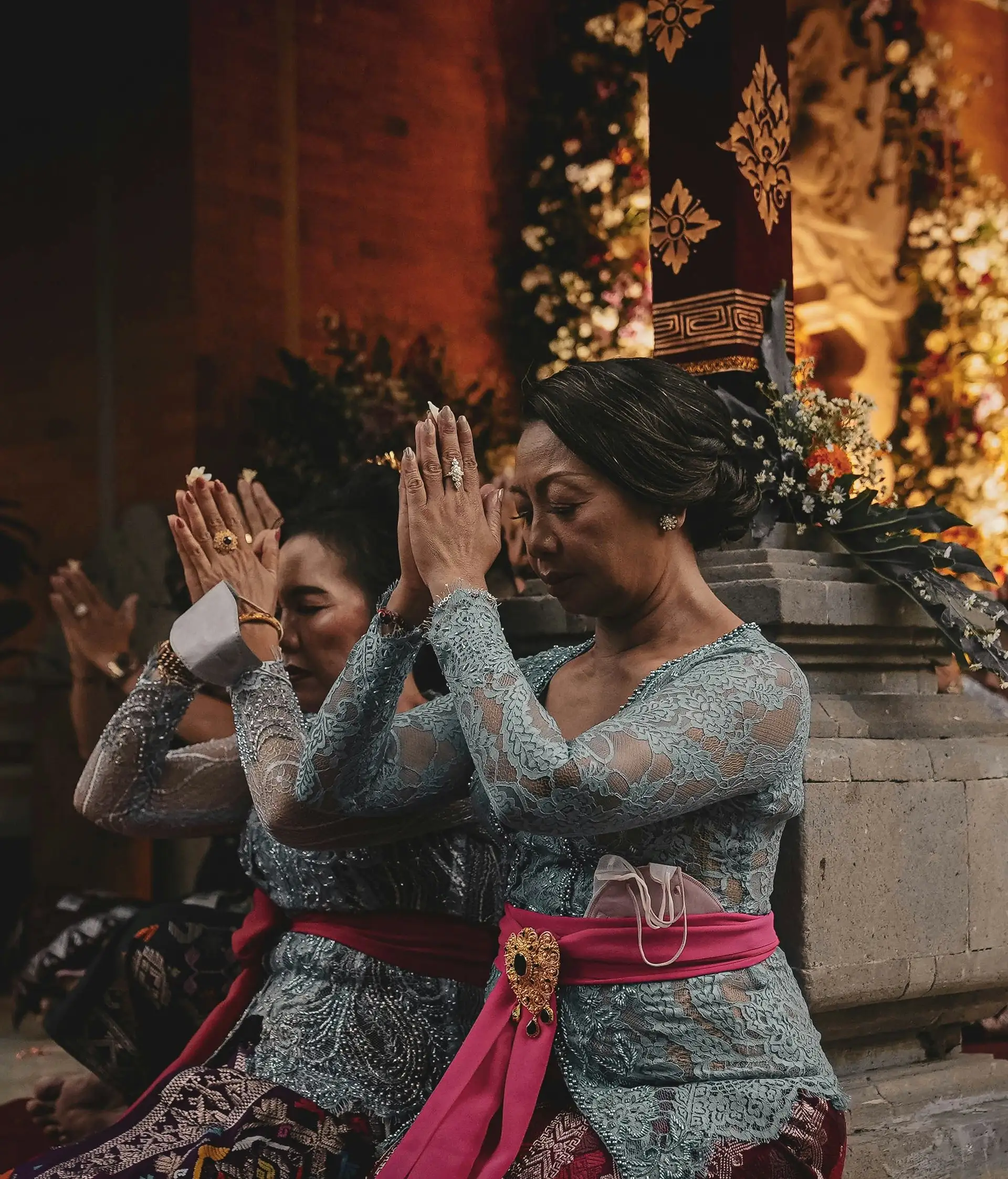 Travel in Asia - Women kneeling in respectful gestures during a traditional Balinese ceremony