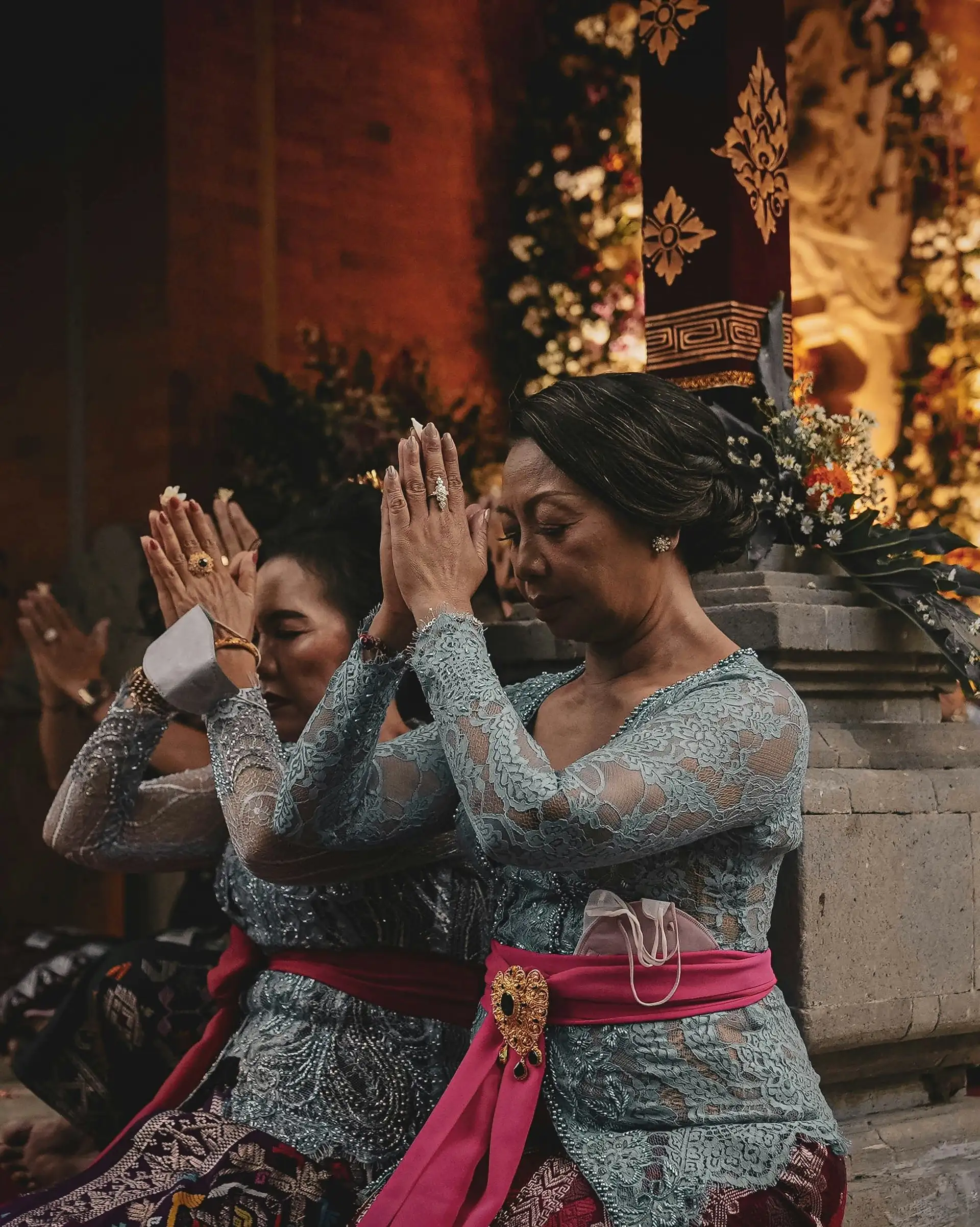 Travel in Asia - Women kneeling in respectful gestures during a traditional Balinese ceremony