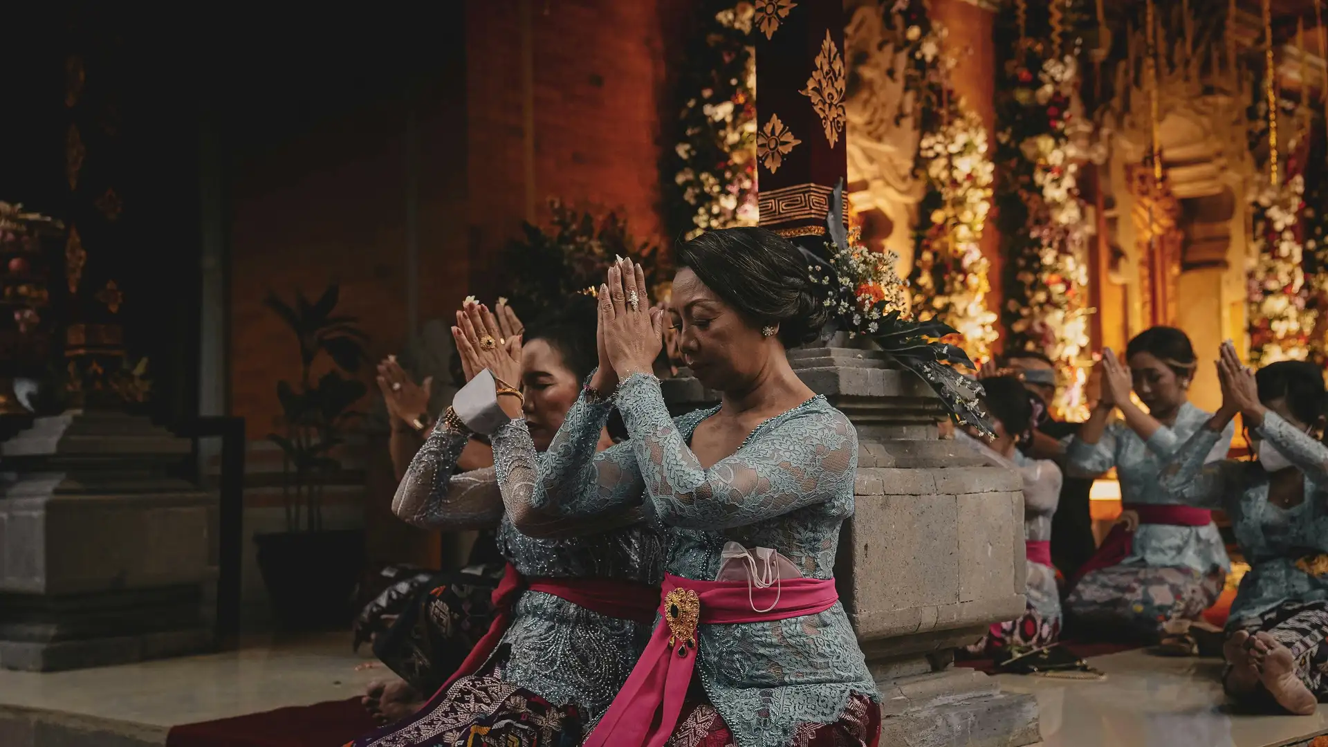 Travel in Asia - Women kneeling in respectful gestures during a traditional Balinese ceremony