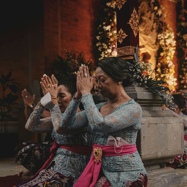 Travel in Asia - Women kneeling in respectful gestures during a traditional Balinese ceremony