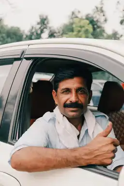 Voyage au Sri Lanka — Chauffeur privé local souriant à la fenêtre de son véhicule pour un circuit sur mesure.