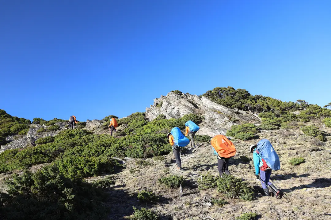 randonneurs gravissant un sentier escarpé le long d'une crête rocheuse à haute altitude à Taïwan