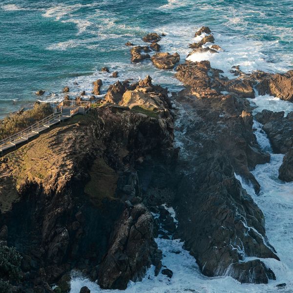 Sentier de bois sinuant le long des falaises escarpées de Byron Bay