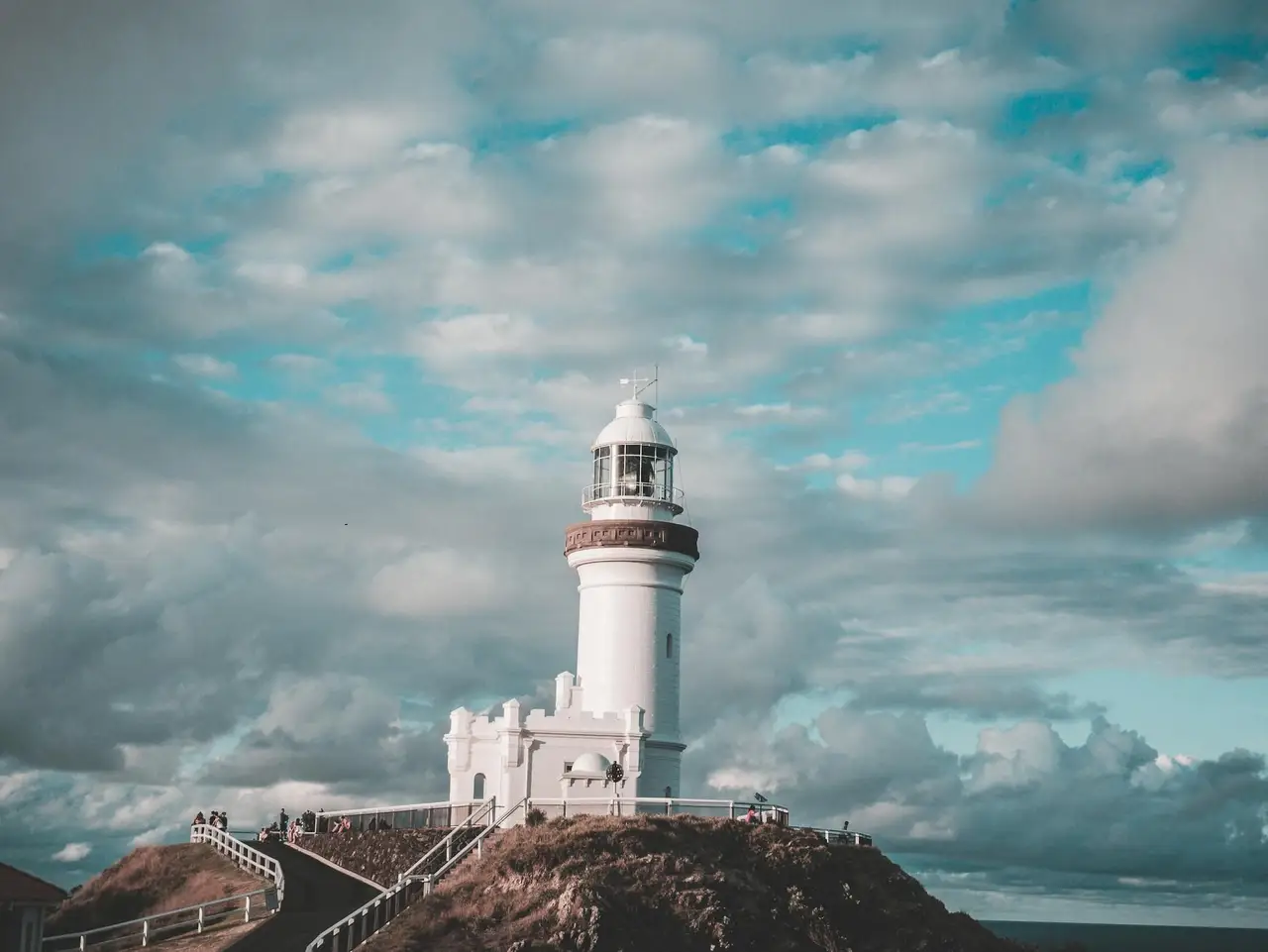 Phare blanc de Byron Bay dominant l'océan sous un ciel nuageux