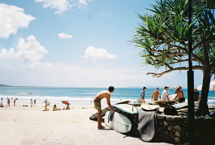 Jeunes surfeurs se préparant sur la plage ensoleillée de Noosa en Australie
