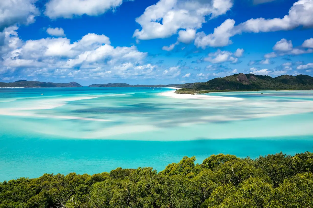 Bancs de sable d'un blanc pur serpentant dans les eaux dégradées de bleu turquoise de Whitehaven Beach