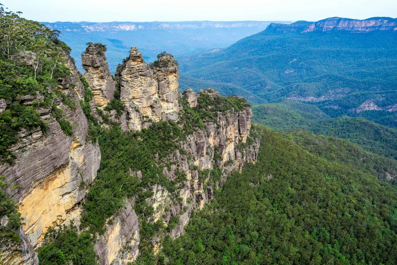Les Trois Sœurs, formations rocheuses emblématiques, surplombant l'immensité verdoyante des Blue Mountains