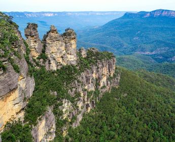 Les Trois Sœurs, formations rocheuses emblématiques, surplombant l'immensité verdoyante des Blue Mountains