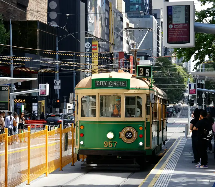 Tramway historique vert et jaune de la ligne City Circle circulant dans les rues animées de Melbourne