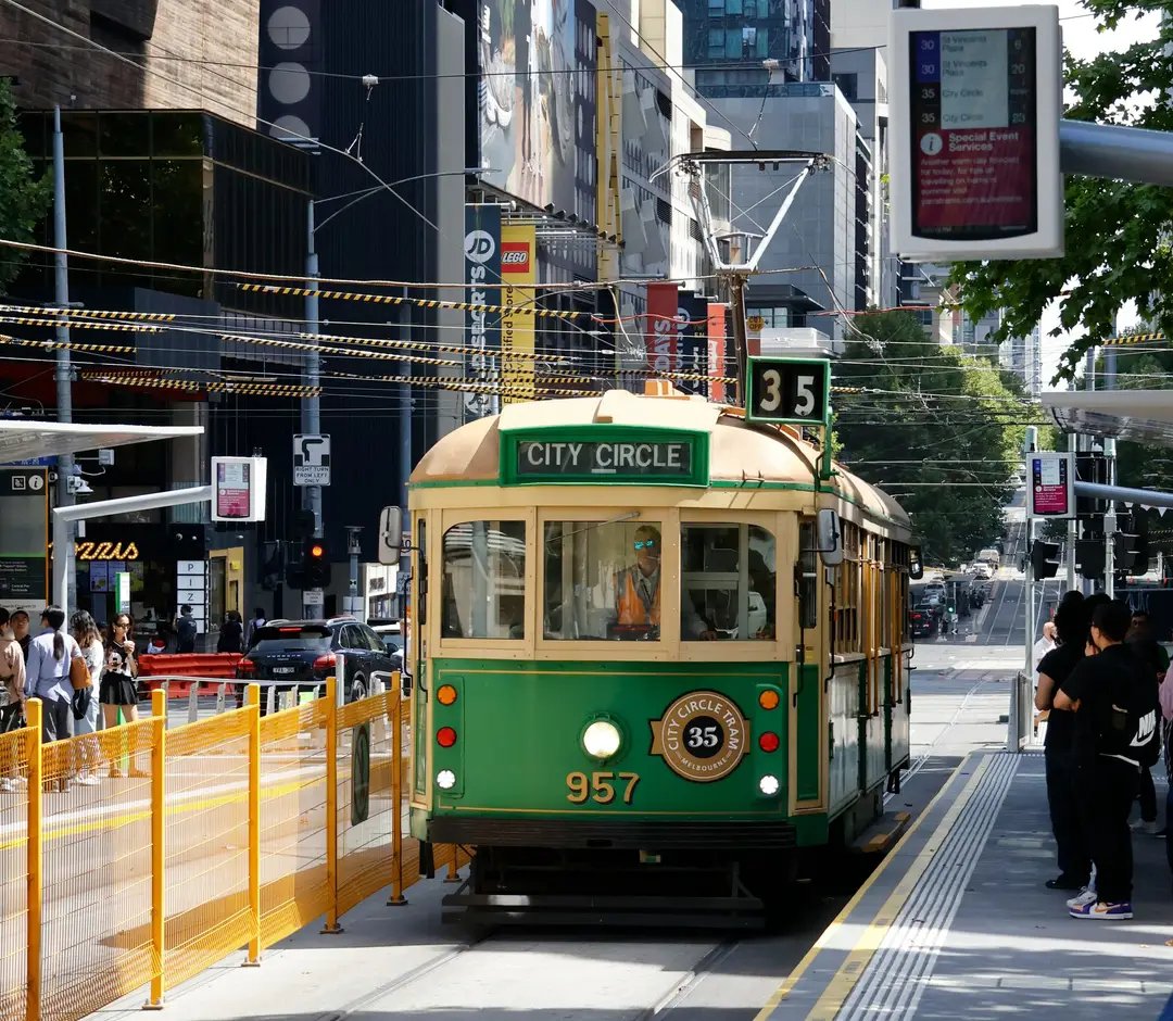 Tramway historique vert et jaune de la ligne City Circle circulant dans les rues animées de Melbourne