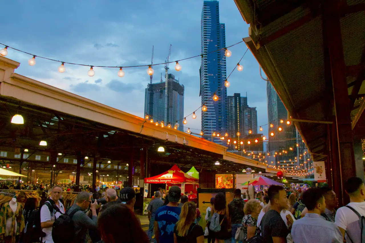 Allée animée du marché nocturne de Queen Victoria à Melbourne sous des guirlandes lumineuses
