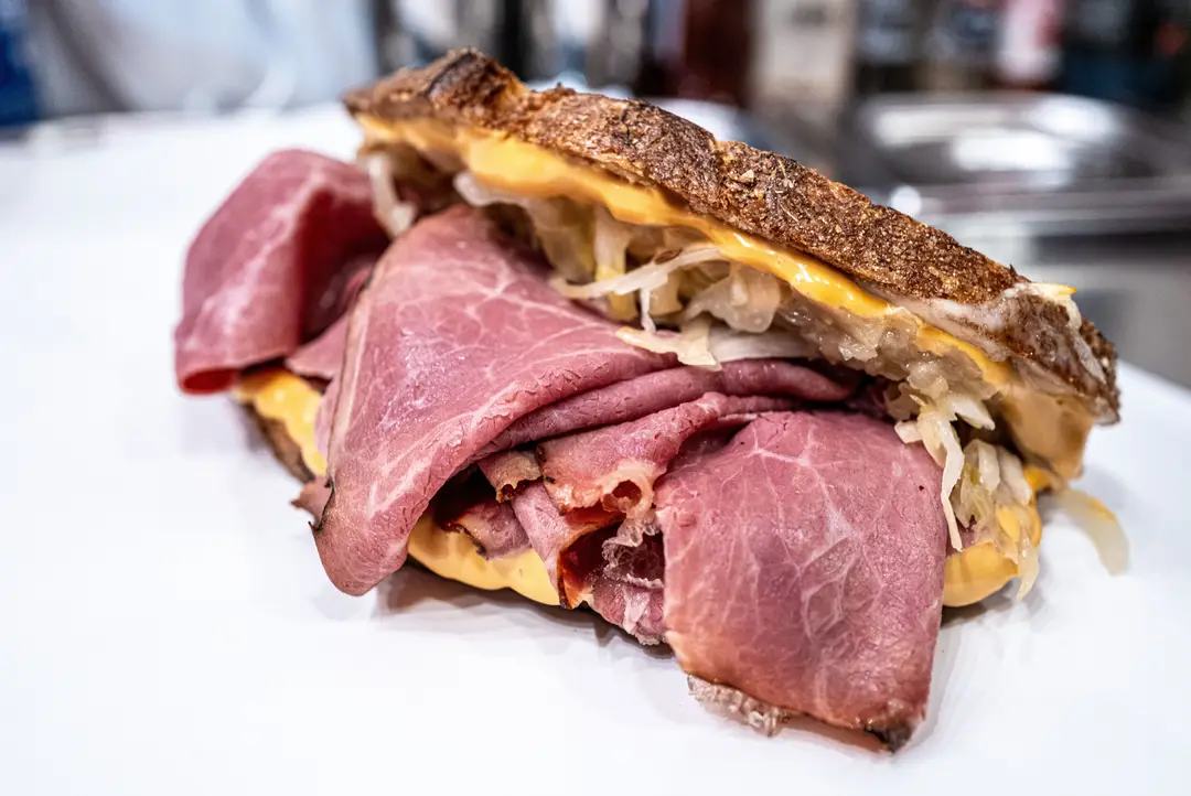 Un sandwich au pastrami accompagné de fromage