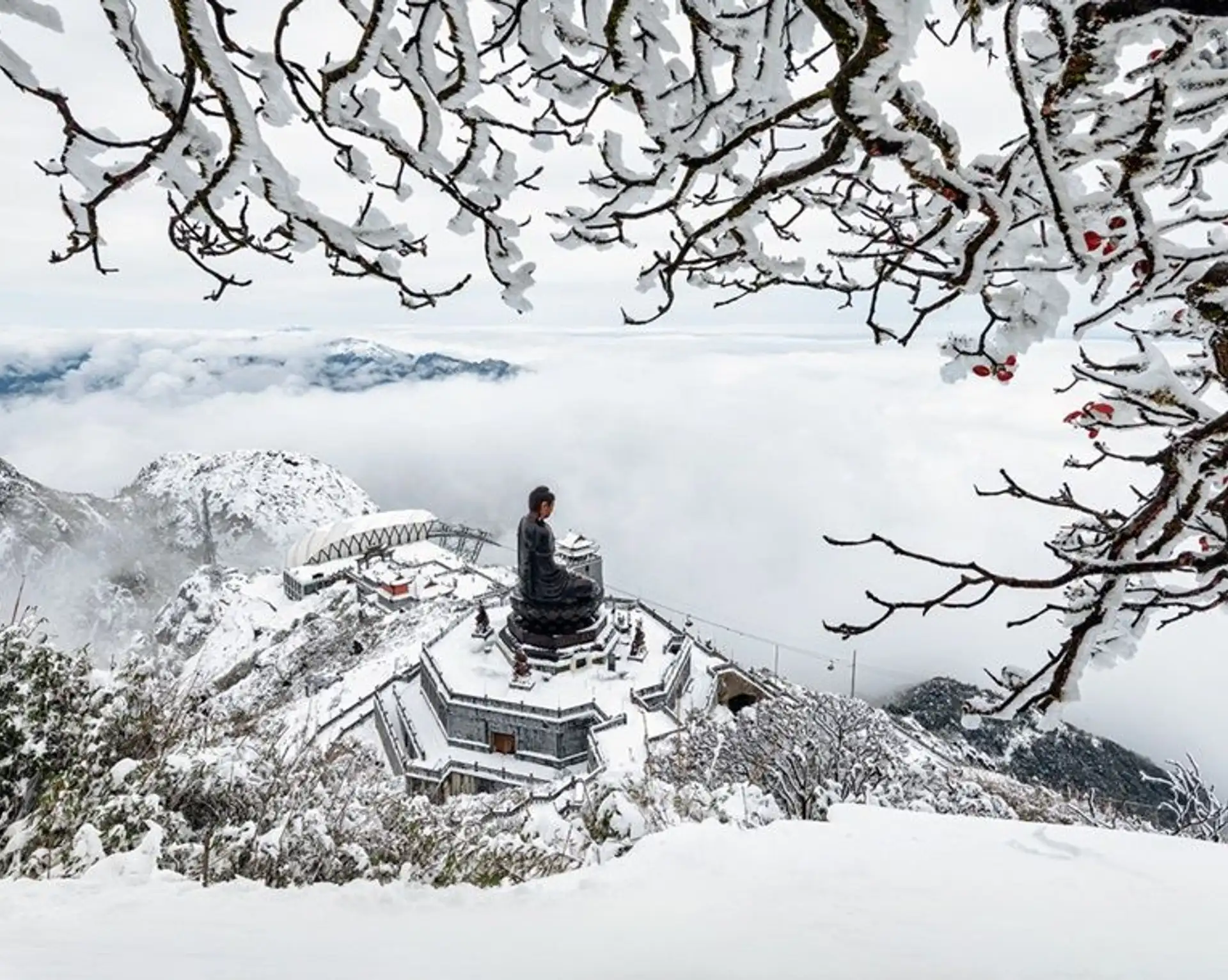 Paysage hivernal de montagne enneigée et givrée surplombant une mer de nuages à Sapa dans le nord du Vietnam.