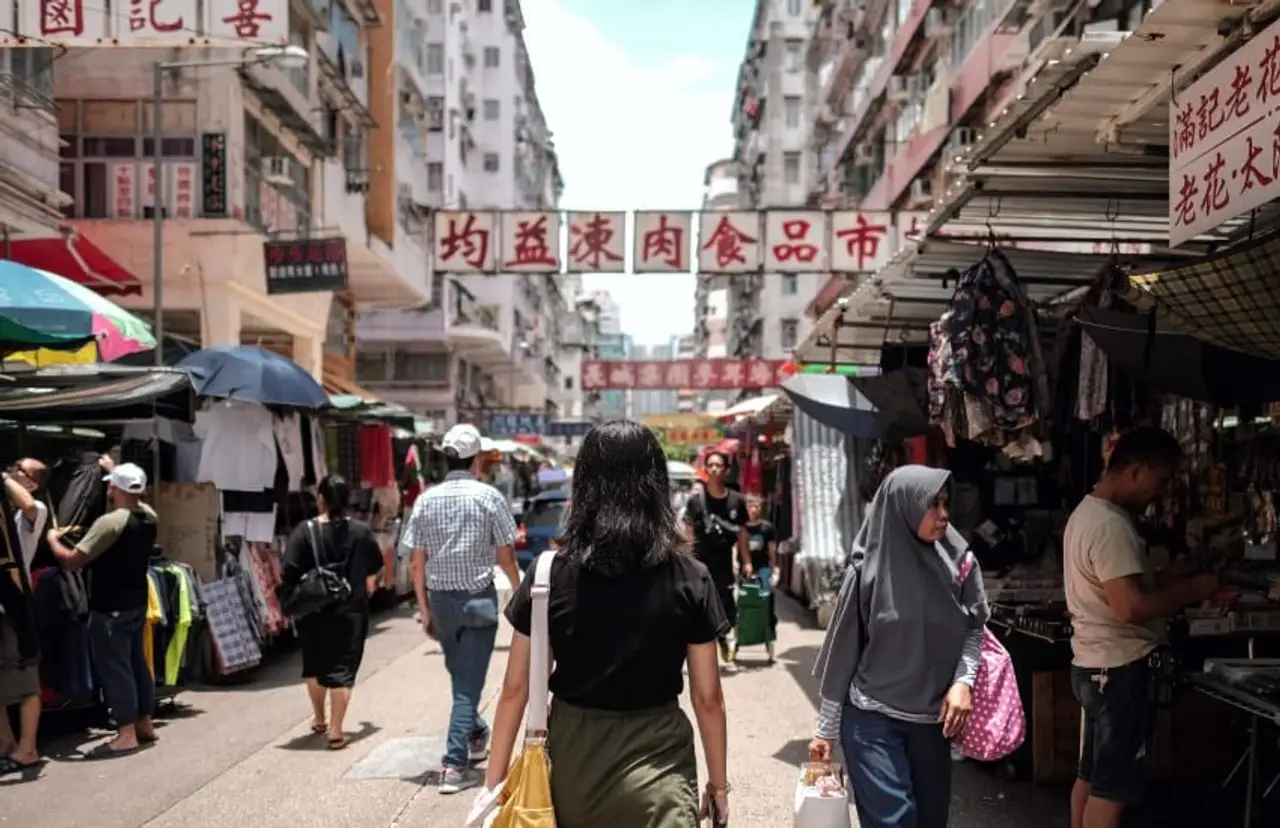 Vie quotidienne à Hong Kong – Foule et étals de marché traditionnels dans une rue animée du quartier de Mong Kok.