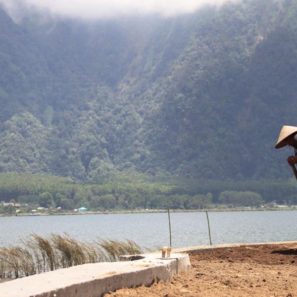 Voyage en Indonésie : Agriculteur local travaillant la terre au bord de l'eau