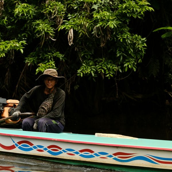 Voyage en Indonésie : Homme naviguant sa pirogue motorisée