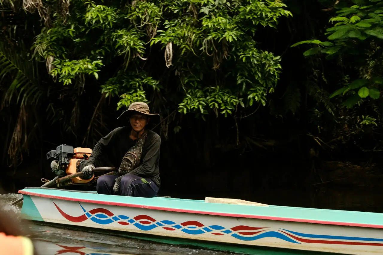 Voyage en Indonésie : Homme naviguant sa pirogue motorisée